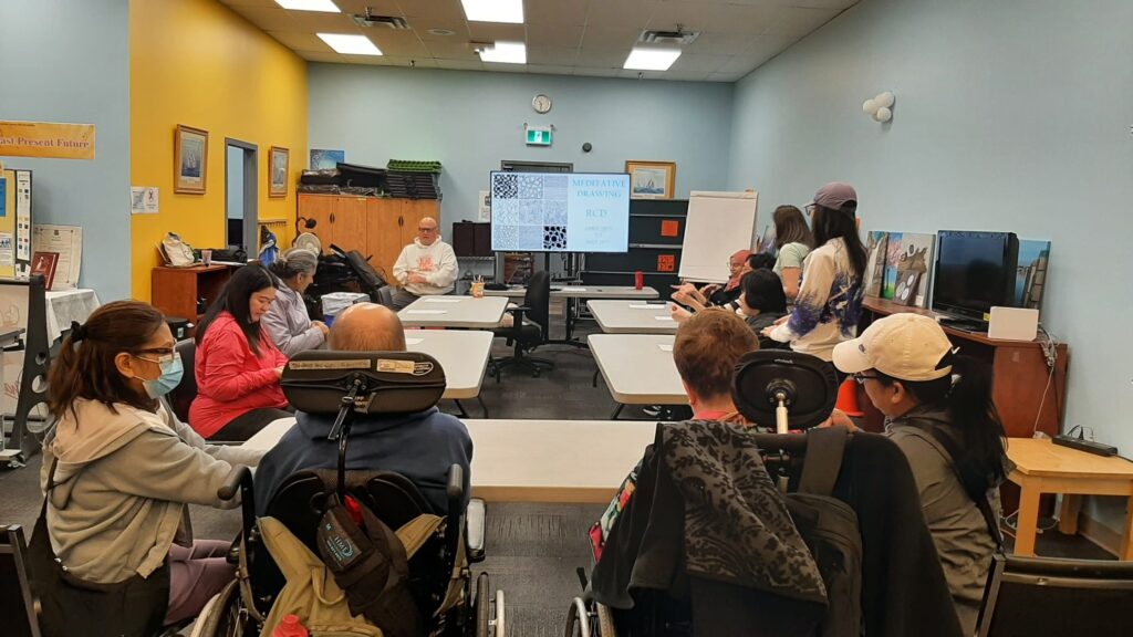 A group of people in a presentation for meditative drawing at Richmond Center for Disability.