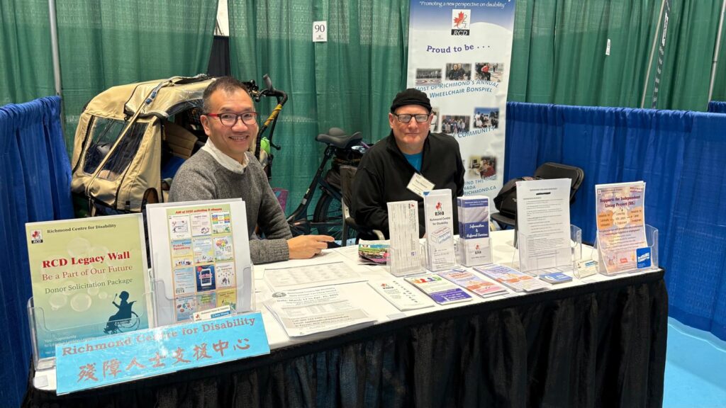 Two People At A Display Booth promoting Richmond Center for Disability.